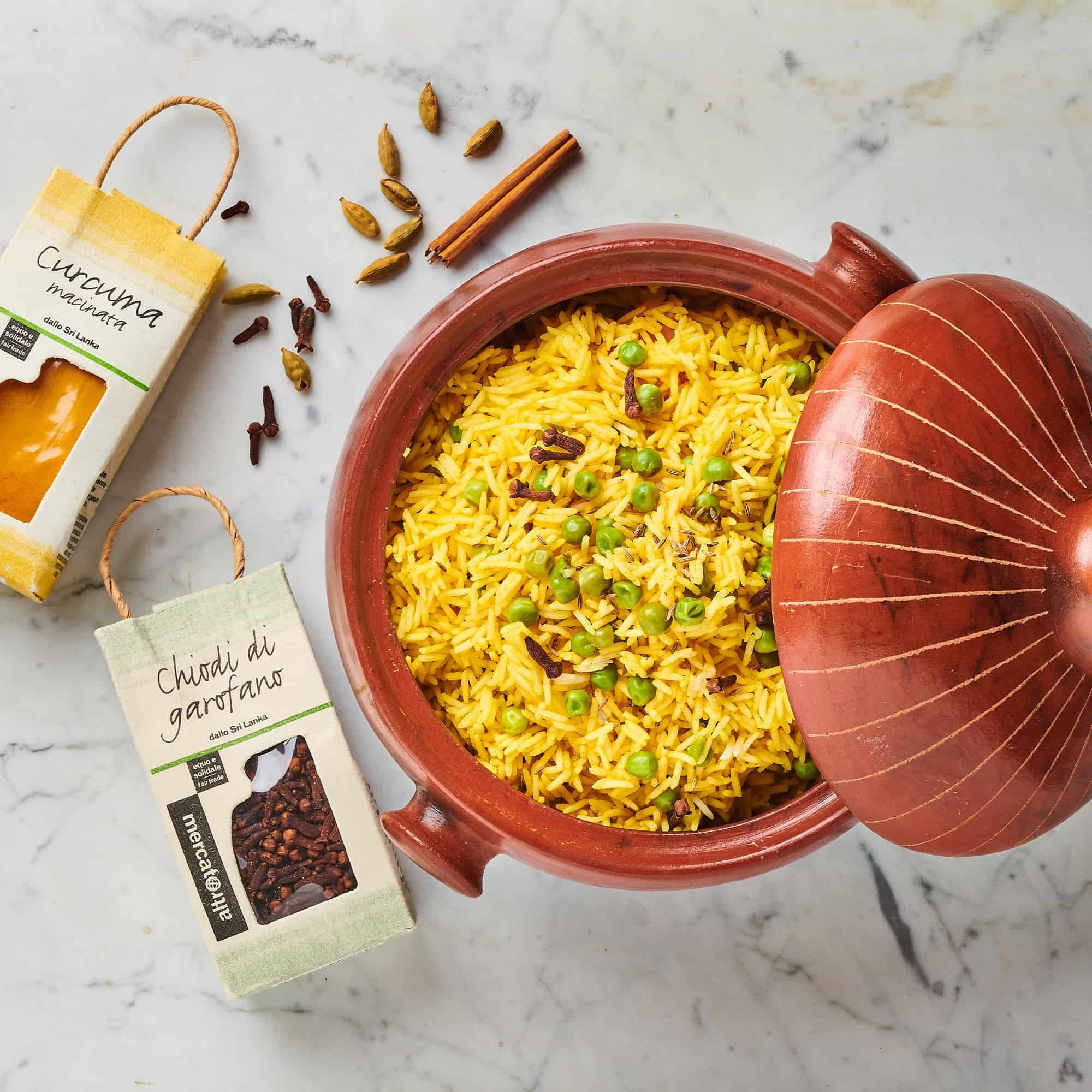 Riso speziato con chiodi di garofano, curcuma e cardamomo in pentola di terracotta